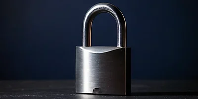 A heavy steel padlock, closed, against a dark navy background.